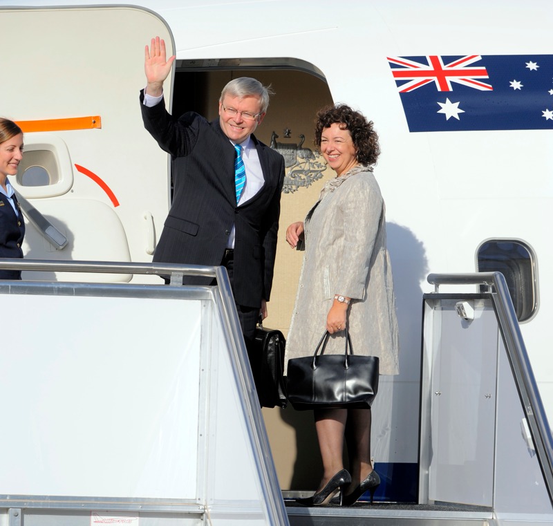 Thérèse Rein and Kevin Rudd wave to the media before boarding their plane to Washington at the Canberra Airport, 23 March 2009.